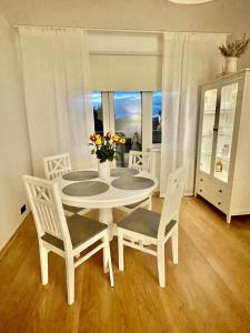 哈普萨卢Keskuse apartment with a balcony的窗户客房内的白色桌椅