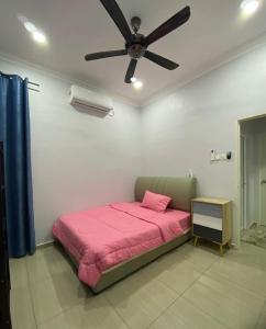 马六甲Rumah Putih Homestay (RPH)的卧室配有粉红色的床和吊扇