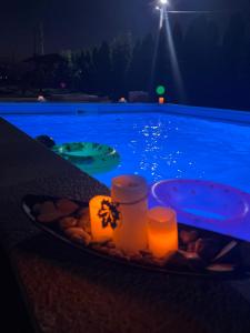 CîrceaCasa Cojocaru的游泳池旁桌子上放着一盘食物和蜡烛