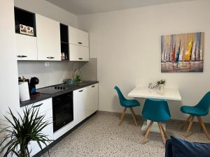 扎达尔Apartment Renata的厨房配有白色橱柜和桌椅