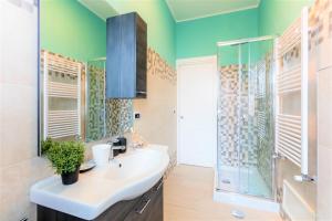 罗马Hostly - Art & Color Rome Midtown - 3BR 2BA的一间带水槽和玻璃淋浴的浴室
