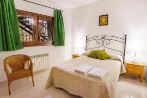 RoníCasa Xaupí Gran的一间卧室配有一张带绿色窗帘的床和一把椅子