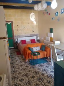 维多利亚Triesti Home的一间卧室配有带橙色床单和桌子的床
