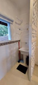 乌巴图巴Solarium Flats Itagua - Ubatuba SP的白色的浴室设有水槽和窗户。