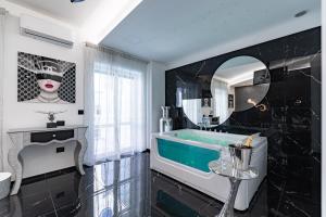 莱切Prezioso suites & rooms的带浴缸和镜子的浴室