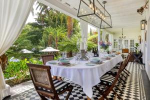 开普敦Villa Coloniale Schumacher Luxury Retreat的一间配备有白色桌椅的用餐室