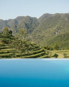 Pu LuongPù Luông Ecolodge的两边的山景,前方有一棵树