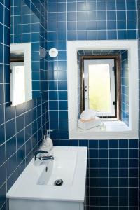 维塞乌VisHostel的蓝色瓷砖浴室设有水槽和镜子