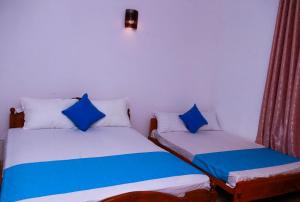 马特勒Blue Waves Madiha的两张睡床彼此相邻,位于一个房间里