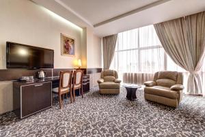 HatneTerra Nova Sport&Spa Hotel的酒店客房配有椅子和平面电视。