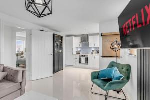 怀门德姆Modern Apartment in Wymondham的一间带绿色椅子的客厅和一间厨房