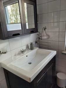 PogumLa Petite Gloire的浴室设有白色水槽和镜子