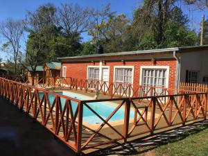 伊瓜苏港Posada Enki的一座房子前面的带木桥的游泳池
