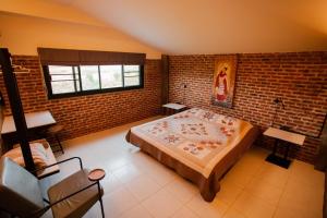 帕府SuanGlangNa的一间卧室设有一张大床和砖墙