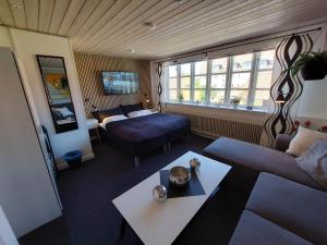 斯卡恩Toftegården Guesthouse - Rooms的酒店客房设有床和客厅。