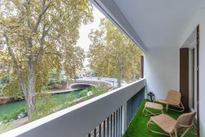 图卢兹Frida - 2 chambres - Balcon的阳台配有两把椅子,享有河景