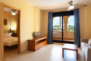 卡内拉岛Apartamentos Playamarina的带沙发、电视和窗户的客厅
