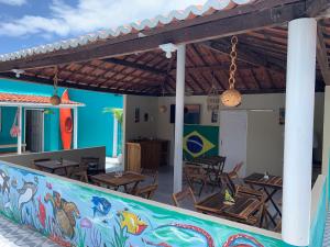 嘎林海斯港Pousada Verdes Mares Porto De Galinhas的餐厅设有桌椅和色彩缤纷的墙壁