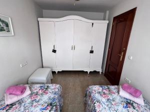 BelicenaCasa Rural Xauen的一间卧室配有两张床和白色橱柜