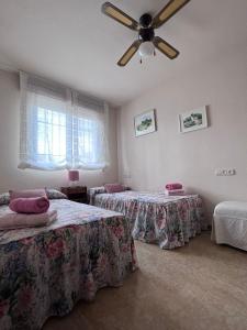 BelicenaCasa Rural Xauen的一间卧室配有两张床和吊扇