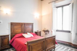 锡耶纳锡耶纳拉契卡住宿加早餐旅馆的一间卧室配有一张带红色床单的床和一扇窗户。