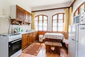 维谢格拉德维谢格拉德温德加兹公寓的厨房配有木制橱柜和白色冰箱。