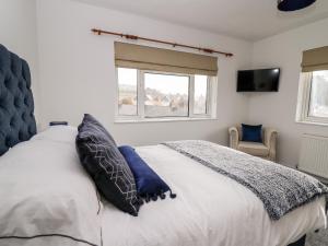 阿伯里斯特威斯Ty Melyn的卧室配有带蓝色枕头的大型白色床