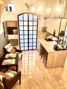 维多利亚300yr old, self catering, tiny house in Victoria Centre, Gozo的厨房以及带柜台和桌子的起居室。