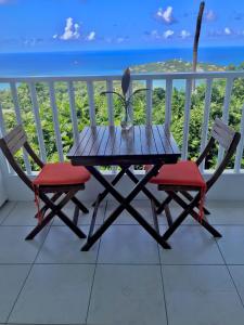 卡斯特里Morne SeaView Apartments的海景阳台上配有一张木桌和两把椅子