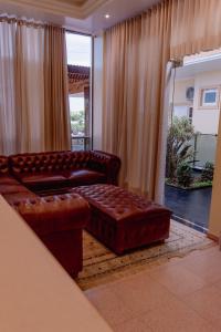 圣维森特HAUER HOTEL的客厅配有真皮沙发和搁脚凳
