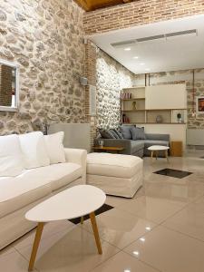 帕特雷Blue Domino Luxury City Villa Patras的客厅配有白色家具和石墙