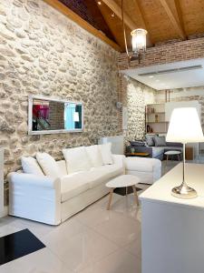 帕特雷Blue Domino Luxury City Villa Patras的客厅配有白色沙发和石墙