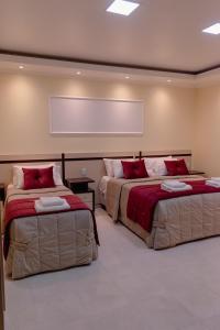 圣维森特HAUER HOTEL的客房内的两张床和红色枕头