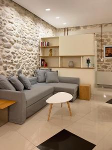 帕特雷Blue Domino Luxury City Villa Patras的客厅设有灰色的沙发和石墙