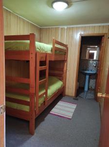 卡斯特鲁La Minga Hostel的小屋内带两张双层床的客房