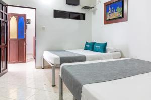内瓦Hotel Ayenda Guadalupe的一间设有两张床和一扇门的房间