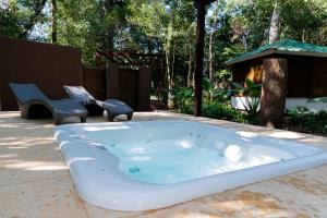 伊瓜苏港卡塔拉塔斯乡村酒店的庭院内一个带两把椅子的按摩浴缸