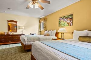 乌雷Box Canyon Lodge and Hot Springs的酒店客房配有两张床和吊扇。
