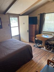 格雷灵Woodland Motor Lodge的一间卧室配有一张床、一张桌子和一张桌子