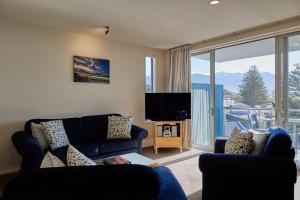 凯库拉Waves on the Esplanade的客厅配有蓝色的沙发和电视
