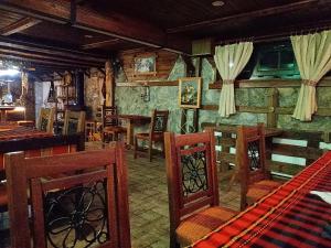 里巴里卡КръчмЪ при Байката Alpin的一间带木椅的用餐室和一间酒吧