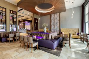 圣约翰斯Best Western Plus St. John's Airport Hotel and Suites的餐厅设有紫色的沙发和桌椅