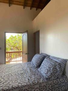 罗阿坦Lila loft- Private one floor bedroom &free parking的一间卧室设有一张床,享有阳台的景色