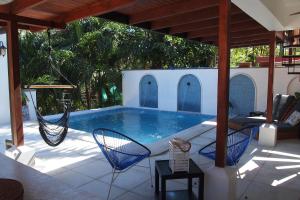 诺萨拉Casa Vitality Nosara的庭院内带吊床的游泳池