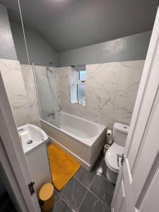 斯特鲁德Cosy home in Rochester, sleeps 6的带浴缸、卫生间和盥洗盆的浴室