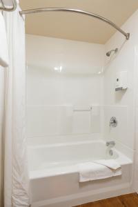 索尔万弗雷德里克国王酒店的白色的浴室设有浴缸和淋浴。