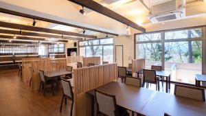 气仙沼市Kyukamura Kesennuma-Ohshima的用餐室设有桌椅和窗户。