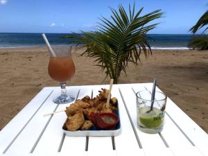 波尔兰特Gîte Studio Marlin的海滩上的餐桌上放着一盘食物和饮料