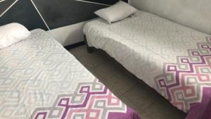 SanctórumHotelito Ejido的两张睡床彼此相邻,位于一个房间里