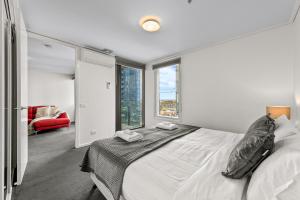 墨尔本独家住宿 - 萨米特公寓的白色的卧室设有床和大窗户